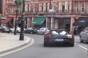 Schaut einem schwarzen Carrera GT beim Driften durch London zu